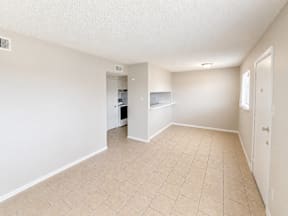 Empty room with beige tiled flooring and white walls located at the pointe apartments in Pasadena, Tx