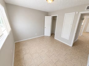 A room with a tiled floor and a large window  located at the pointe apartments in Pasadena, Tx
