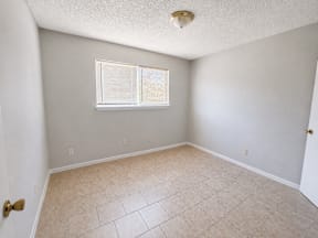 A room with a window and tiled floor with a walk in closet located at the pointe apartments in Pasadena, Tx
