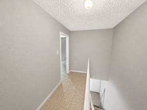 Spacious hallway leading stairs to room located at the pointe apartments in Pasadena, Tx