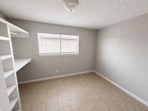 Spacious room with large windows and shelves located at the pointe apartments in Pasadena, Tx