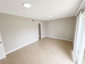 Spacious room with window and door to balcony located at the pointe apartments in Pasadena, Tx
