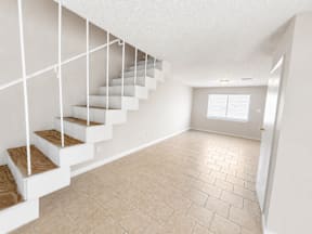 Spacious living room with stairs located at the pointe apartments in Pasadena, Tx