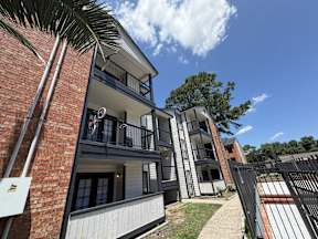 A modern apartment building with balconies located at Canfield Lakes Apartments in Houston TX