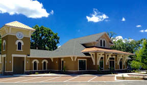 A church with a clock tower and a covered walkway.