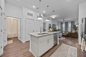 A modern kitchen with a large island and pendant lights.at Address East End, North Carolina