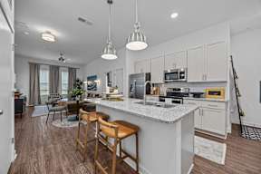 A kitchen with a white countertop and wooden bar stools.at Address East End, Raleigh, 27610