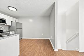 A kitchen with a refrigerator, microwave, and sink.