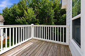 A white deck with a railing and a window.