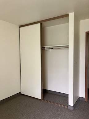 A closet with a white sliding door.