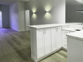 Kitchen with White Cabinets and Living Room with Hard Floor
