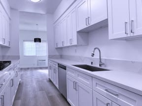 Kitchen With White Cabinets, Sink, and Hard Floor