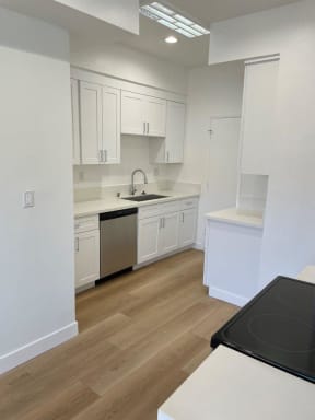 Kitchen with Hard Floors, White Cabinets and Stainless Steel Appliances