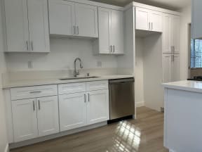 Kitchen with Hardwood Floors, White Cabinets and Stainless Steel Appliances