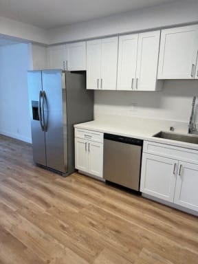 Kitchen with Hardwood Floors, White Cabinets and Stainless Steel Appliances