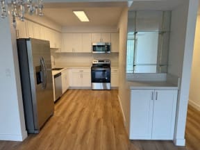 Kitchen with Hardwood Floors, White Cabinets and Stainless Steel Appliances