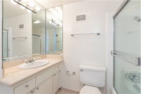 A white toilet sits next to a sink in a bathroom.