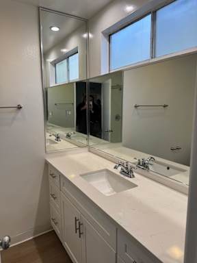 Bathroom with sink, mirror and window.
