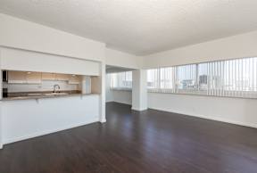 A large empty room with wooden floors and white walls.