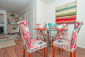 A dining room with a table and colorful chairs at Laurel Parc apartments in Shreveport, LA.