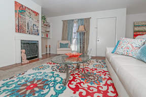Large model living room with a white couch and a glass coffee table at Laurel Parc apartments in Shreveport, LA.