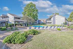 A sunny day at a Laurel Parc apartment complex with a pool and lounge chairs at Laurel Parc apartments in Shreveport, LA.