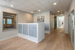 A long hallway with a white reception desk and a framed picture on the wall.