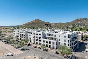 A large white building with a parking lot in front of it.