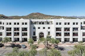 A large white building with a parking lot in front.