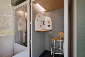 A white chair sits in front of a white door.
