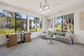 A modern work from home lounge with couches and a table and chairs.