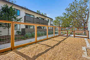 A wooden fence encloses a gravel yard.