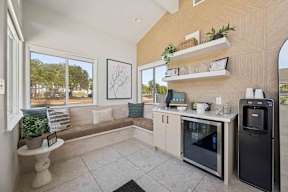 A leasing office seating area with a black fridge, and water cooler.