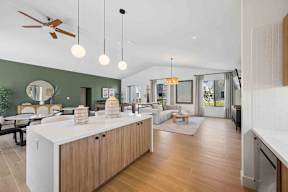 A modern kitchen with a white countertop and wooden cabinets.