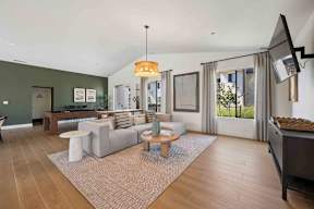 A clubhouse with a grey sofa and a wooden coffee table.