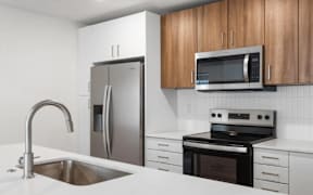 Kitchen with stainless appliances and wood cabinets at The Woods at Copper Ranch Apartments, Hailey, ID