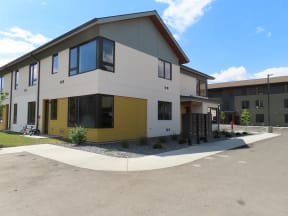 a white and yellow house with a sidewalk in front of it  at Lido Apartment Homes @ Hailey, ID, Hailey, ID 83333
