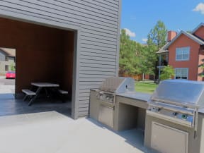 a stainless steel outdoor kitchen with a grill and a picnic table  at Lido Apartment Homes @ Hailey, ID, Hailey, ID 83333