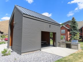 a small gray shed with its door open and a backyard grill  at Lido Apartment Homes @ Hailey, ID, Hailey, ID 83333