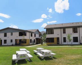 a group of white houses with picnic tables in the grass  at Lido Apartment Homes @ Hailey, ID, Hailey, ID 83333