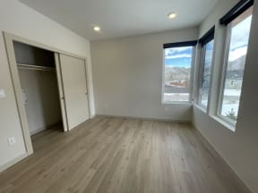 an empty living room with wood floors and large windows  at Lido Apartment Homes @ Hailey, ID, Hailey, ID 83333