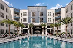 A large building with a pool in front of it. at CODA Apartments , Orlando, FL, 32826