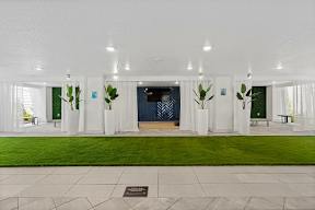 A white building with a green lawn in front. at CODA Apartments , Orlando