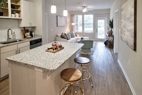 A kitchen with a granite countertop and bar stools at TRAILSIDE VERDAE Apartments , GREENVILLE, SC