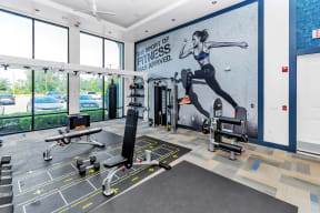 a fully equipped gym with a mural of a woman running on the wall