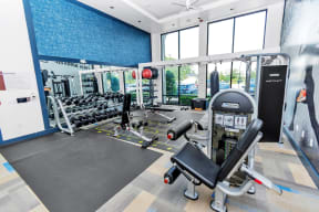 a spacious fitness room with cardio equipment and weights