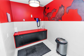 a bathroom with a red and black wall and a black bathtub with a blue shower head