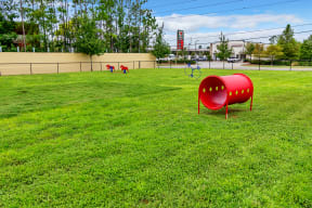 a large grassy area with a red barrel in the middle of it