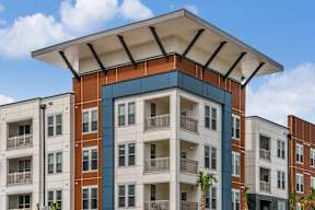 A modern apartment building with a mix of white and brick facades. at CODA Apartments , Orlando, FL, 32826
