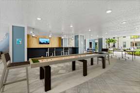 A room with a long table and chairs and a television on the wall. at CODA Apartments , Orlando, 32826